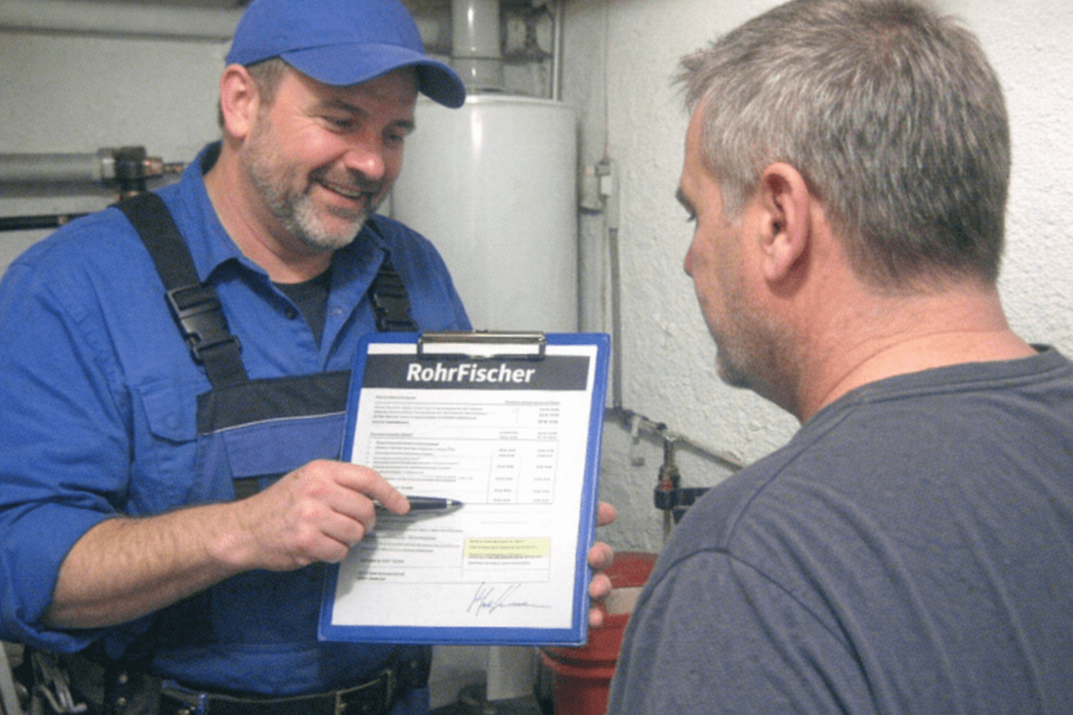 Monteur erklärt einer Bewohnerin die dokumentierten Arbeitsschritte auf einem Einsatzblatt